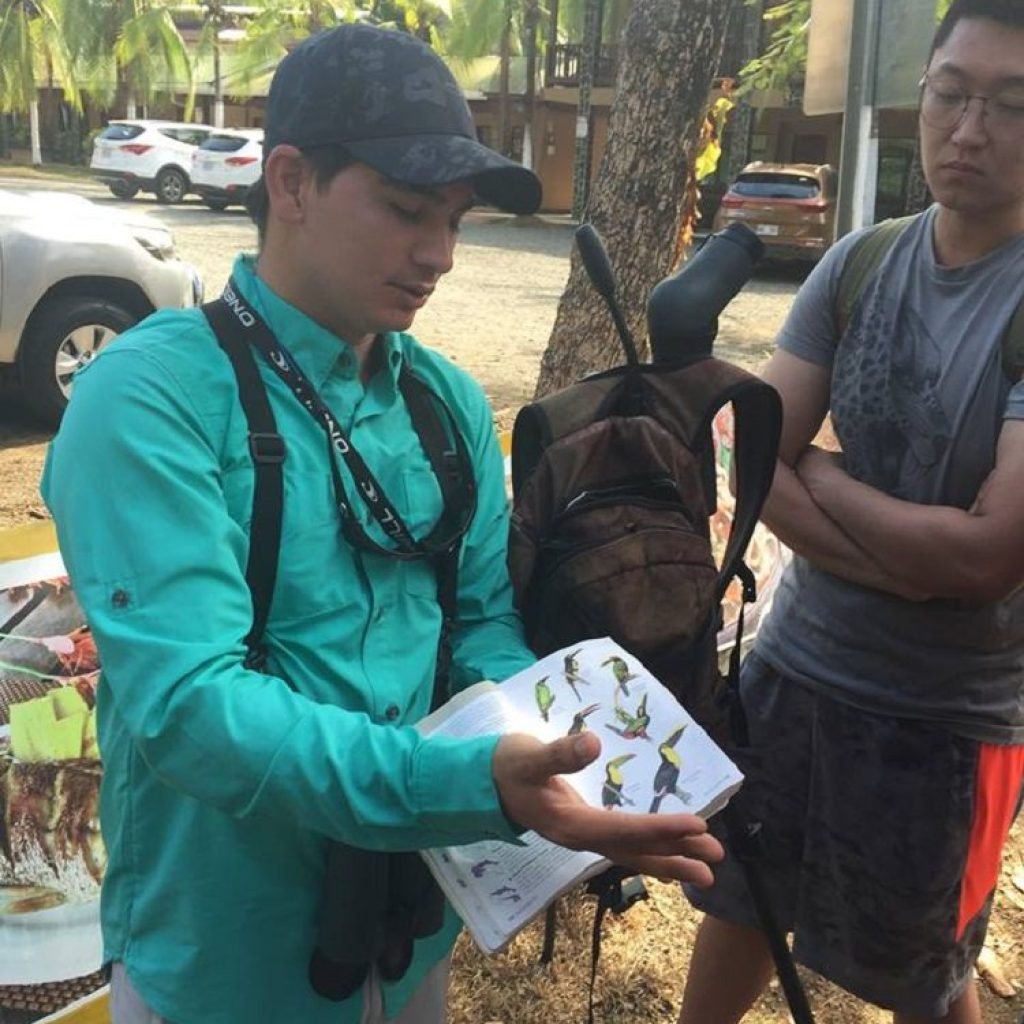 Naturalist guide showing the bird field guide to guests on the Esquipulas tour