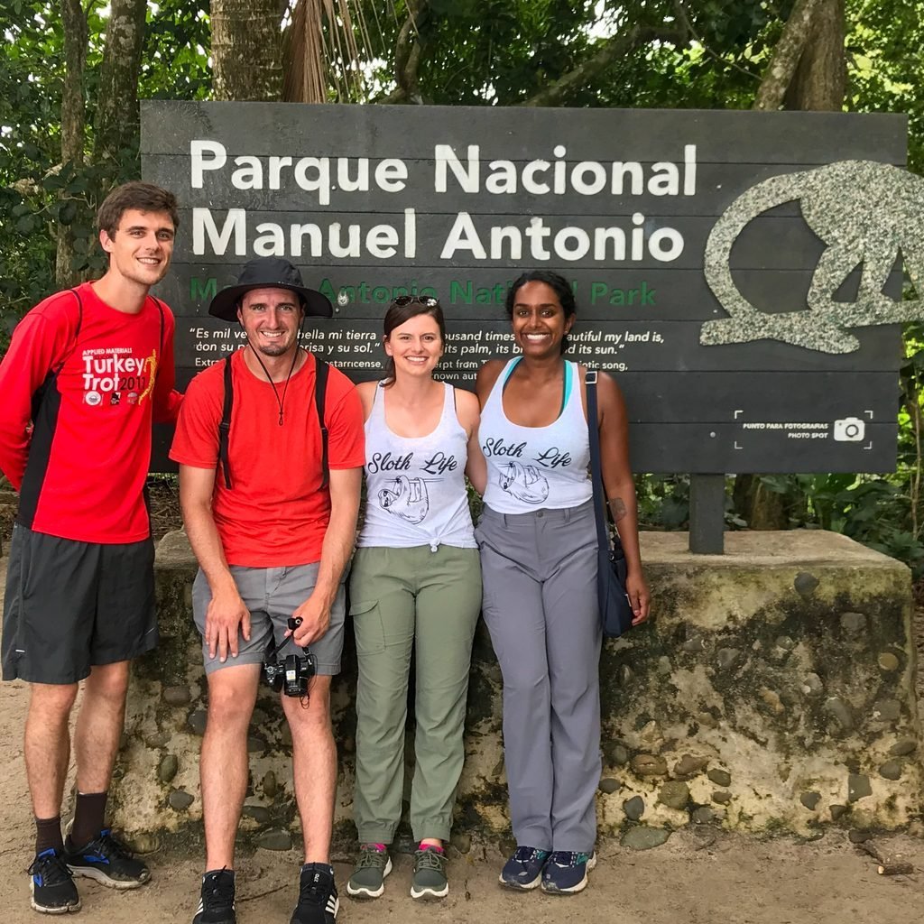 Wakoo Tours group standing at the Manuel Antonio National Park entrance sign on the Classic group tour