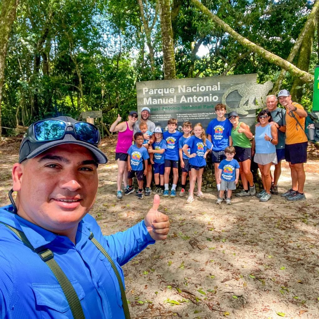 Happy Wakoo Tours group taking a selfie at the Manuel Antonio National Park entrance sign